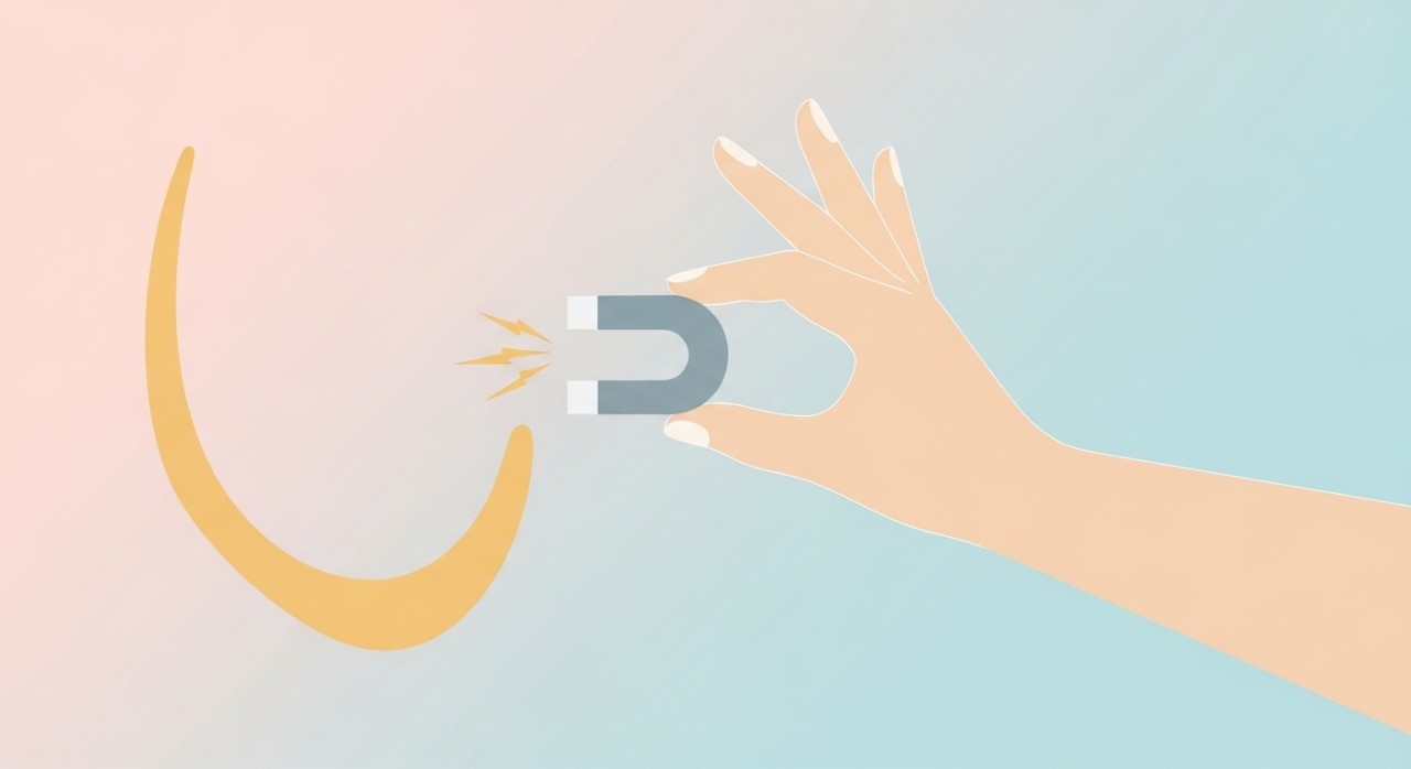 Seseorang sedang menguji ketulenan rantai emas menggunakan magnet kecil.